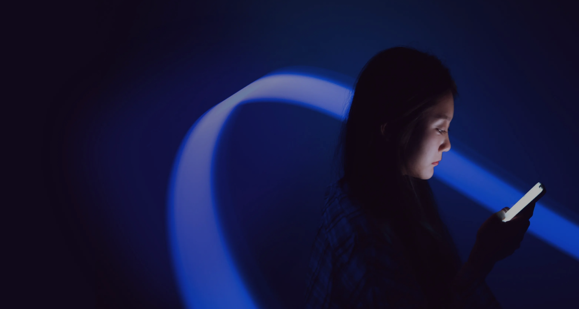 A person looking at a mobile screen in blue light